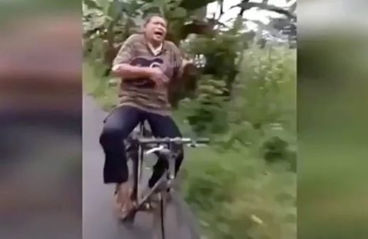 Watch: Bapak-bapak santai nyanyi dan main gitar sambil bersepeda di jalan raya