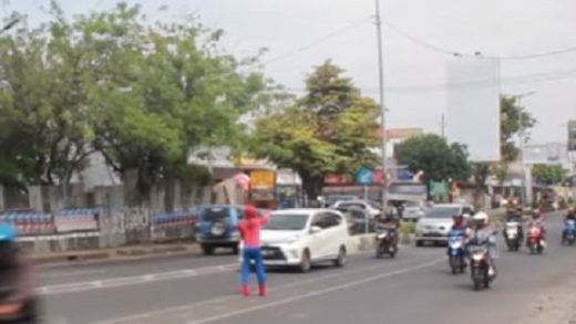 Pria berkostum Spider-Man sibuk mencegah pengendara motor naik ke fly over di Malang