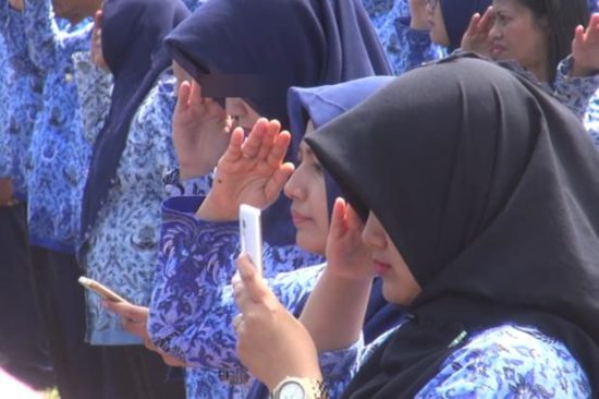 PNS Jombang tangan kanannya hormat, yang kiri pegang HP saat upacara