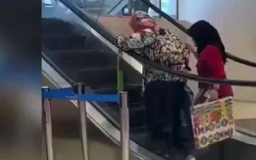 Layaknya treadmill, dua wanita melawan arus di eskalator