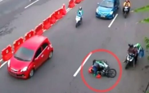 Watch: Pemotor jatuh saat berkendara karena jas hujan terlilit roda sendiri